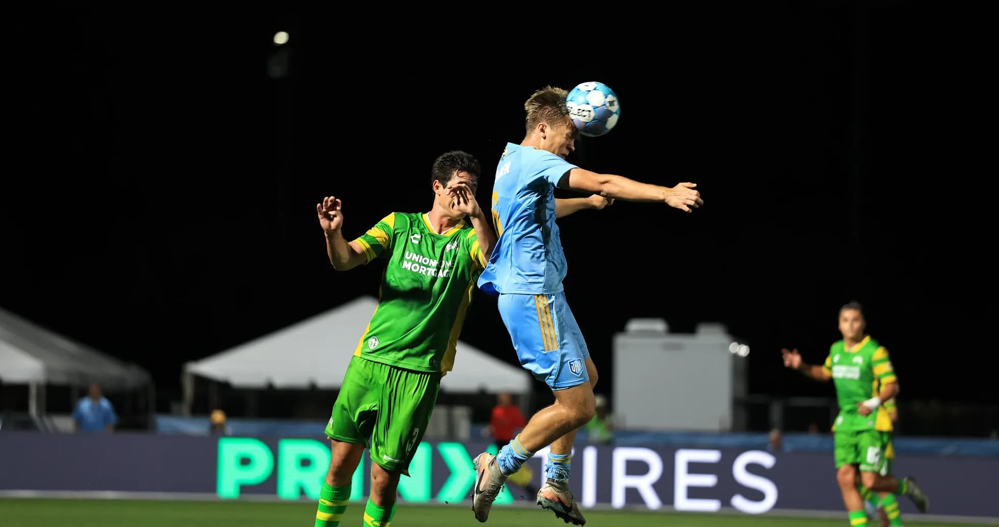Players contesting a header during the match