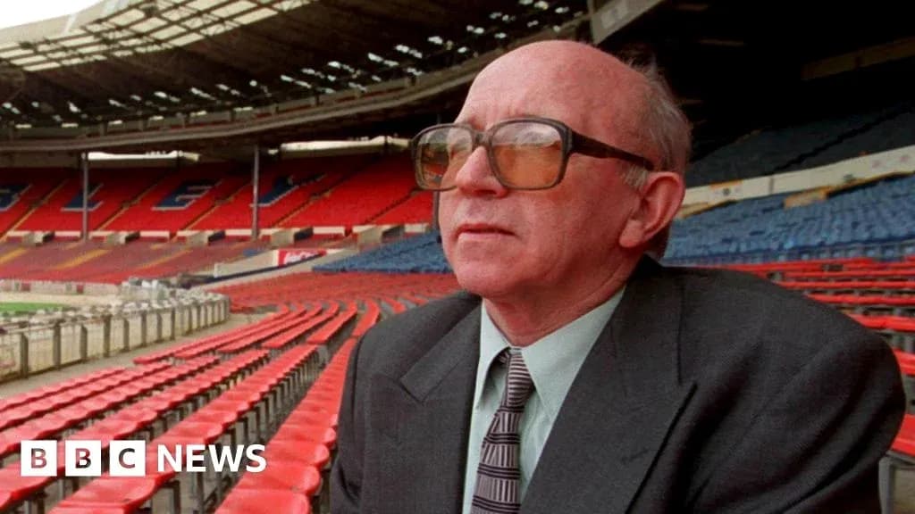 Man seated in empty stadium with red seats