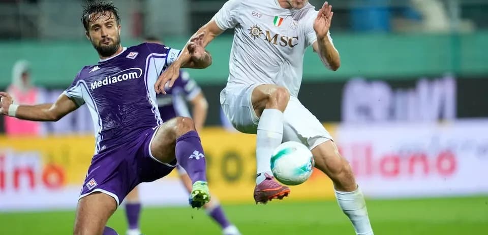 Fiorentina player challenging Napoli opponent for ball