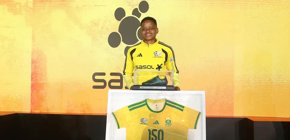 Player holding a green boot and jersey at event