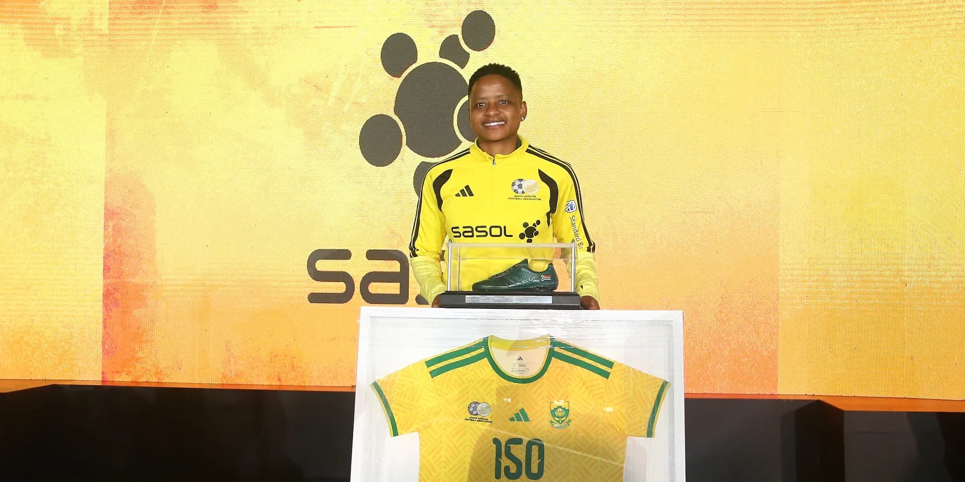 Player holding a green boot and jersey at event