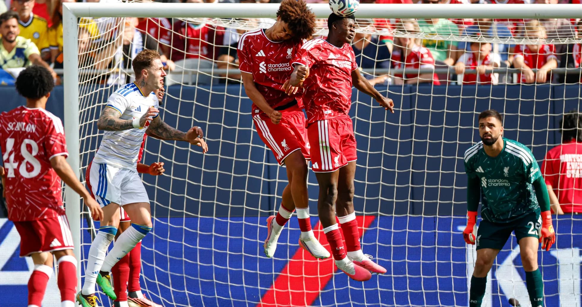 Players jumping to head the ball in goal area