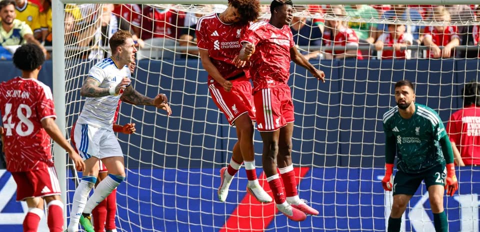 Players jumping to head the ball in goal area