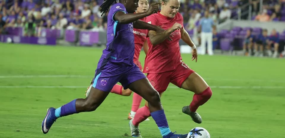 Orlando Pride player dribbling past Boston Legacy defender