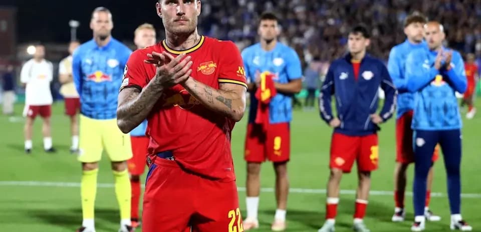 Player applauding with teammates in background after match