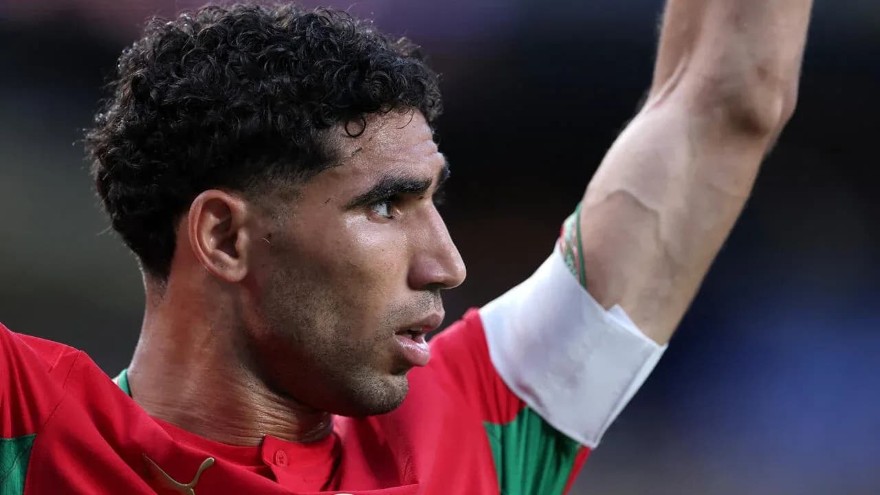 Player celebrating with raised arm wearing Morocco jersey