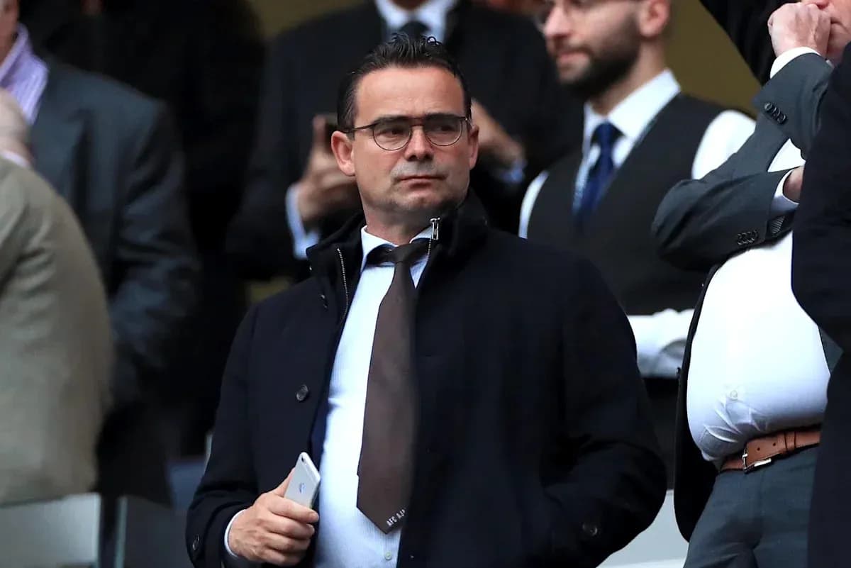 Man in a suit observing from the stands