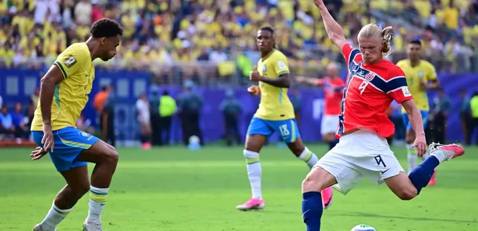 Brazil player defending against Norway striker