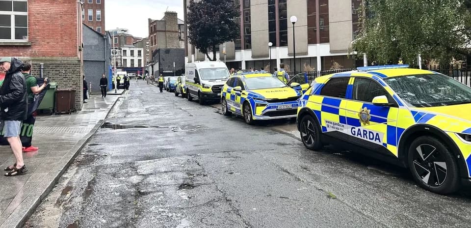 Garda vehicles parked on a wet street
