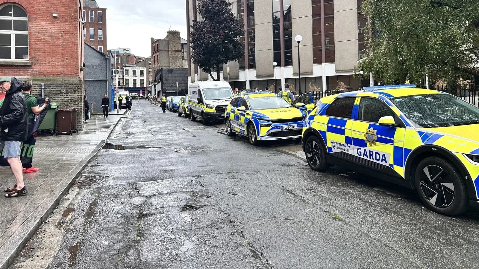 Garda vehicles parked on a wet street