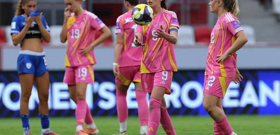 Players in pink jerseys on field during match