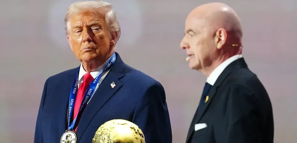 Man holding FIFA award with another speaker nearby