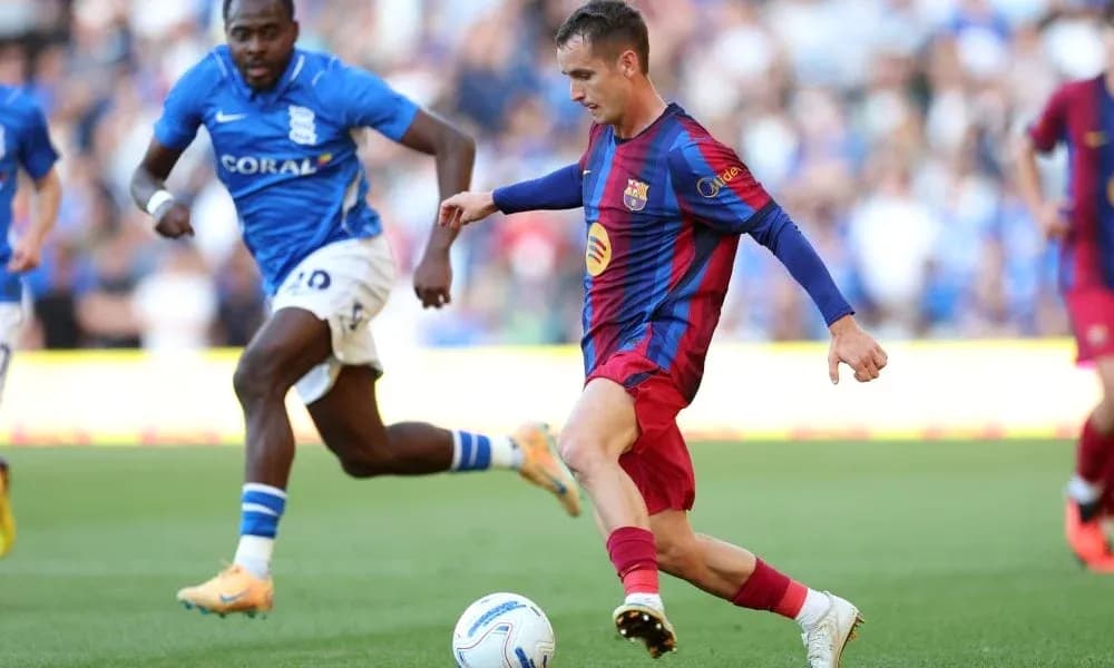 Barcelona player dribbling past Birmingham opponent