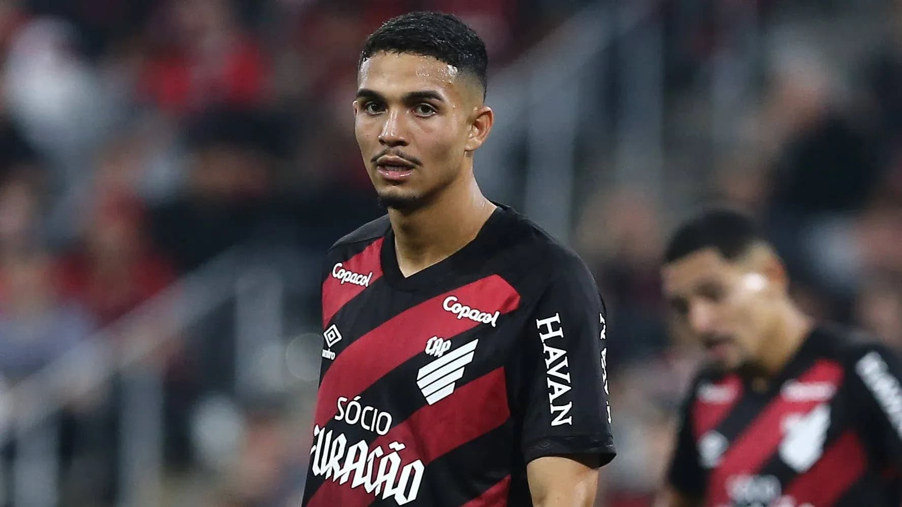 Player wearing red and black jersey on field