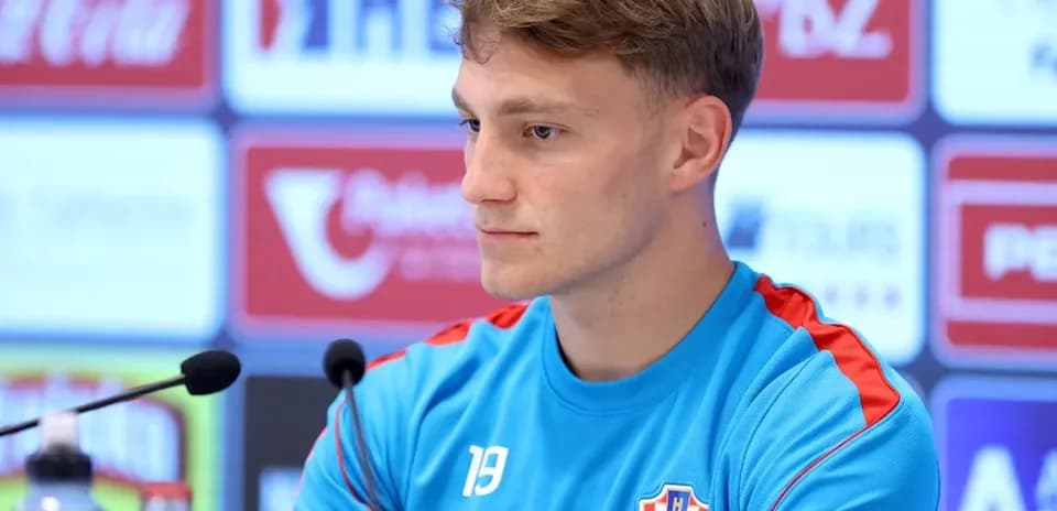 Player at press conference with team jersey on
