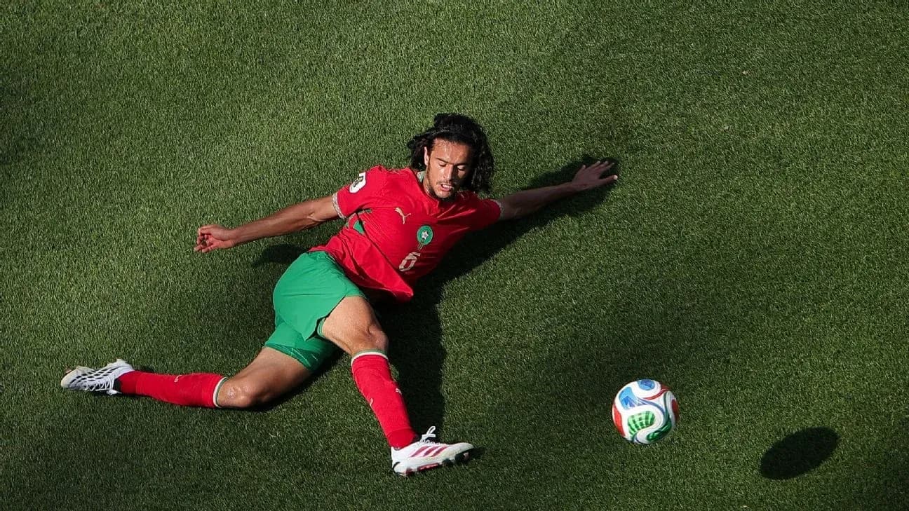 Moroccan player sliding on grass towards ball