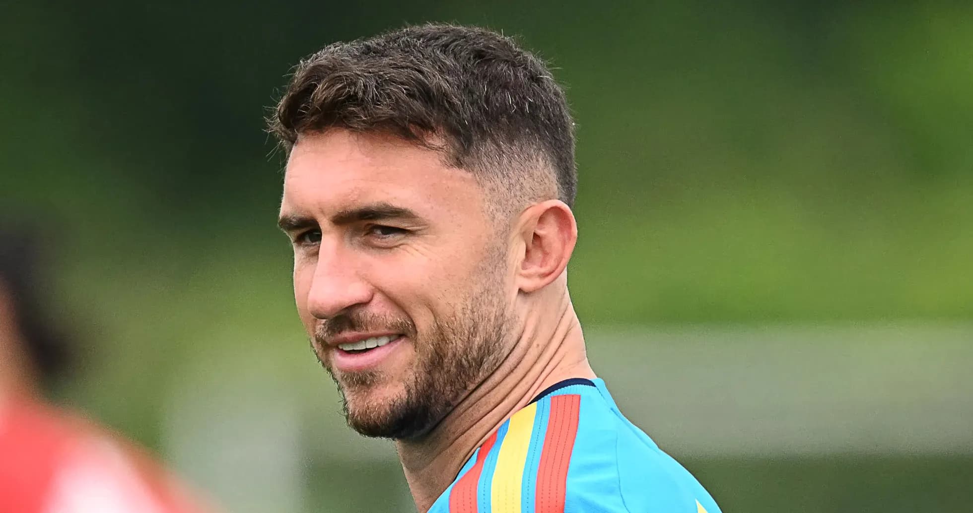 Football player in training attire smiling outdoors