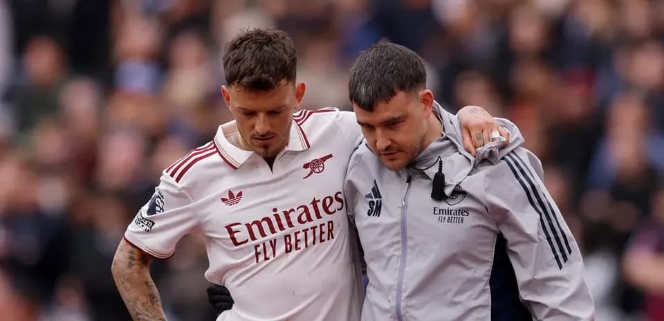 Player being assisted off the field by staff