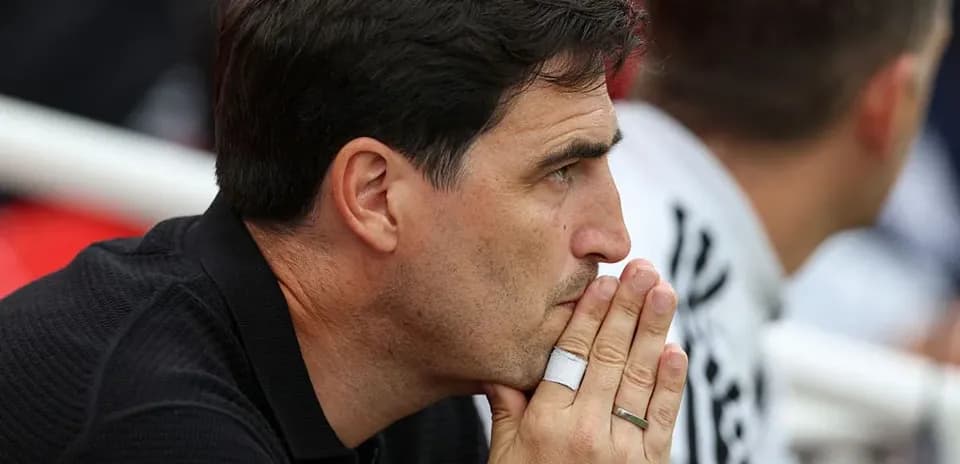 Coach observing the match with hands clasped