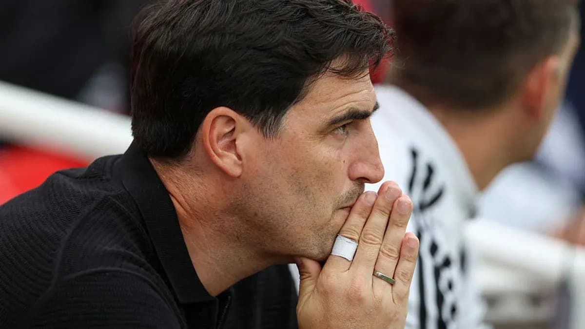 Coach observing the match with hands clasped