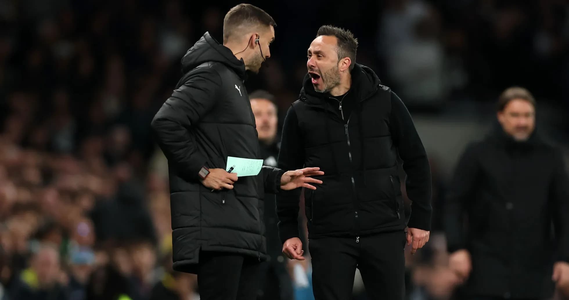 Coaches discussing tactics on the sidelines during match