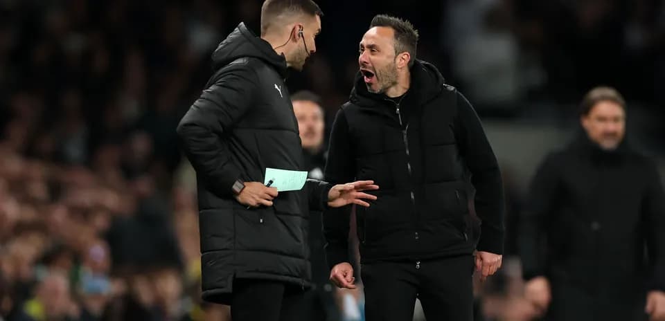 Coaches discussing tactics on the sidelines during match