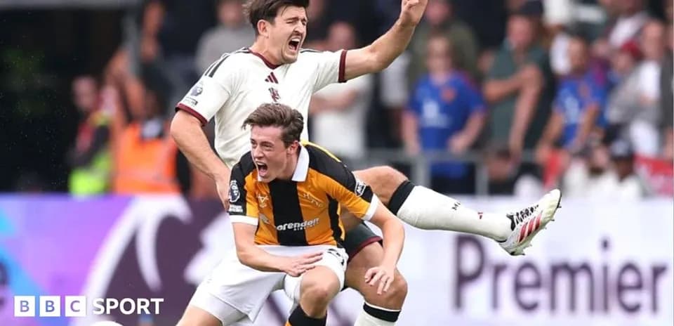 Two football players competing for possession on pitch