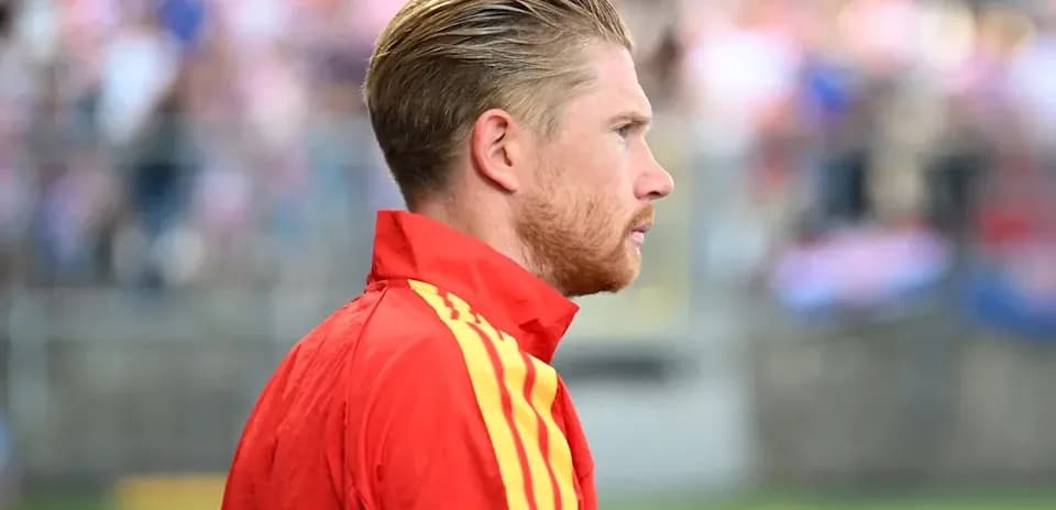 Player in red tracksuit during match warm-up