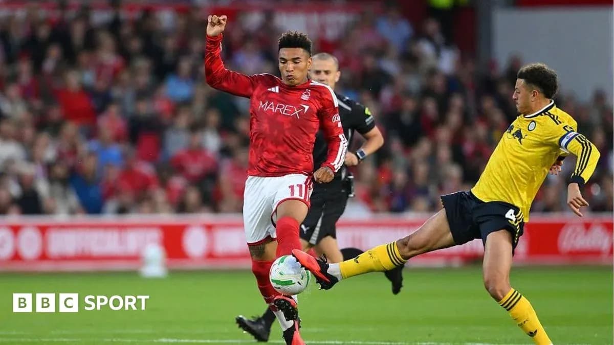 Player in red dribbling past opponent in yellow