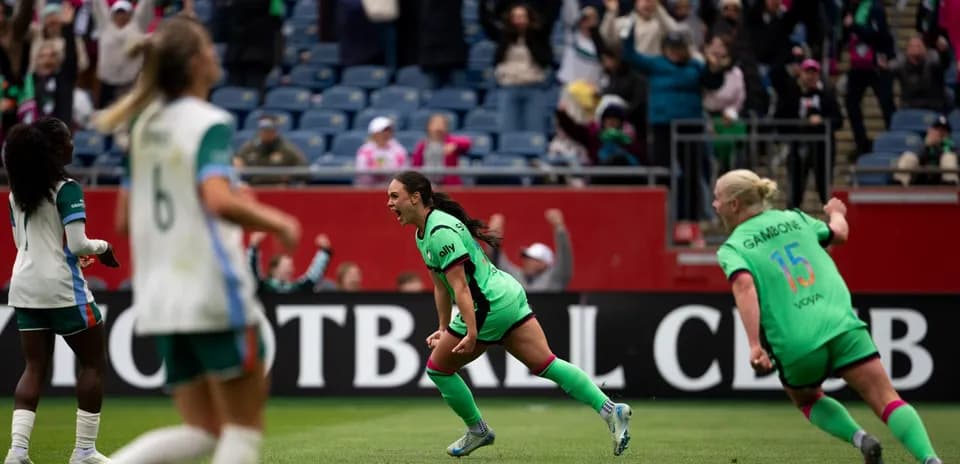 Players celebrating a goal during NWSL match