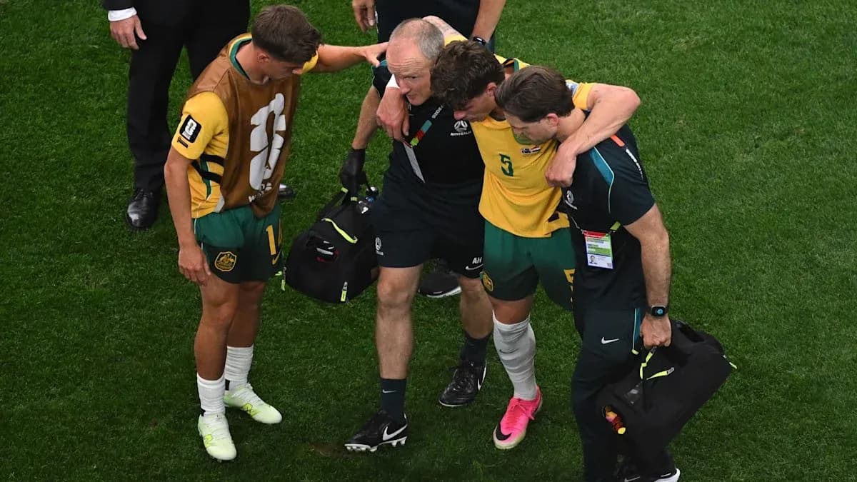 Player being assisted off the field by staff