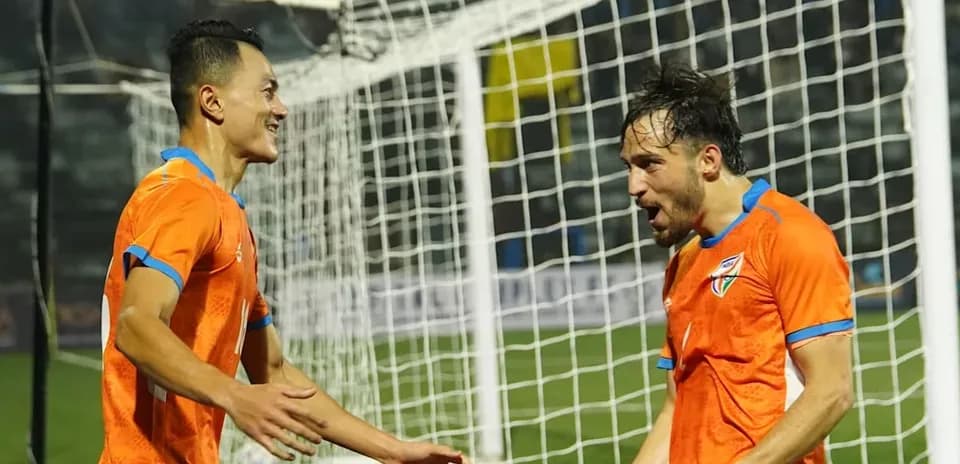 Two players celebrating a goal on the field
