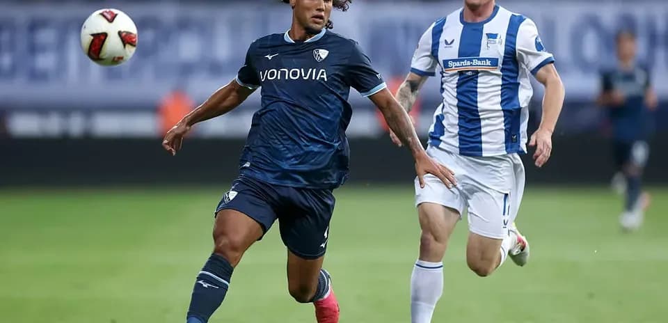 Player dribbling the ball with opponent chasing