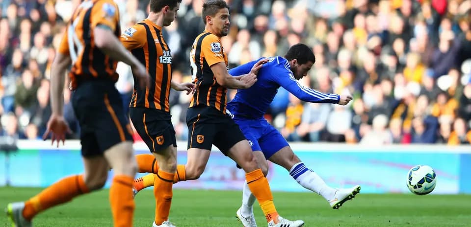 Chelsea player attempting to kick the ball