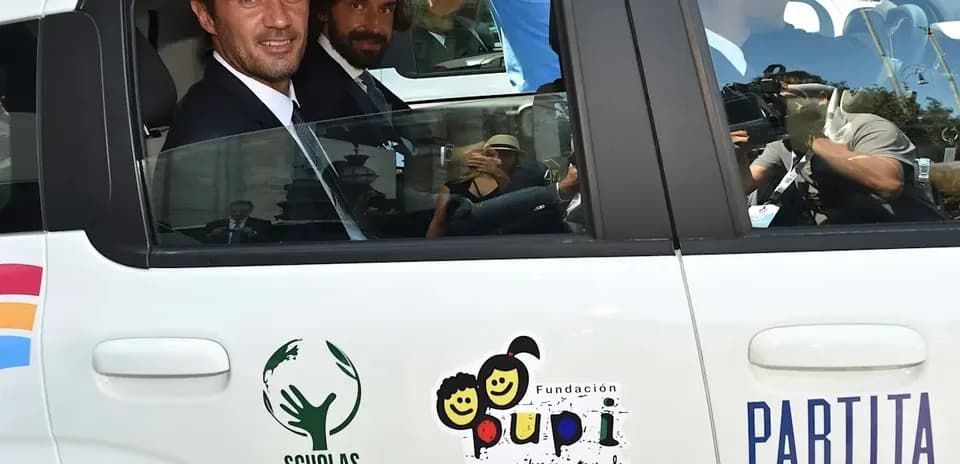 Two men in formal attire inside a car