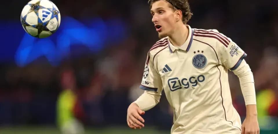 Player in Ajax jersey controlling a soccer ball