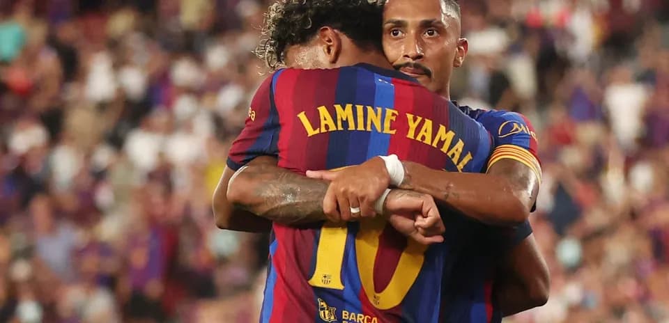 Two FC Barcelona players embracing on the pitch