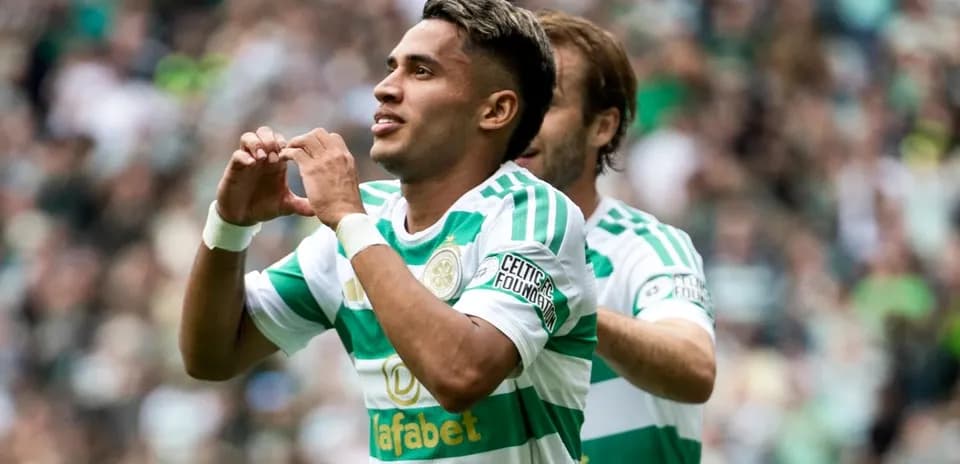 Player celebrating goal with heart gesture on pitch