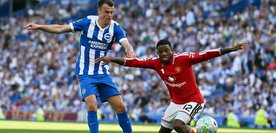 Brighton player challenging Manchester United opponent