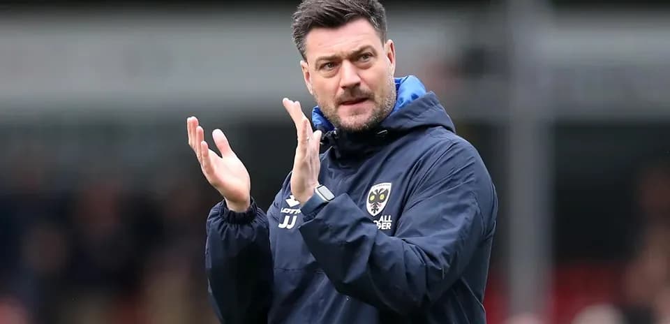 Manager clapping on the sidelines during match