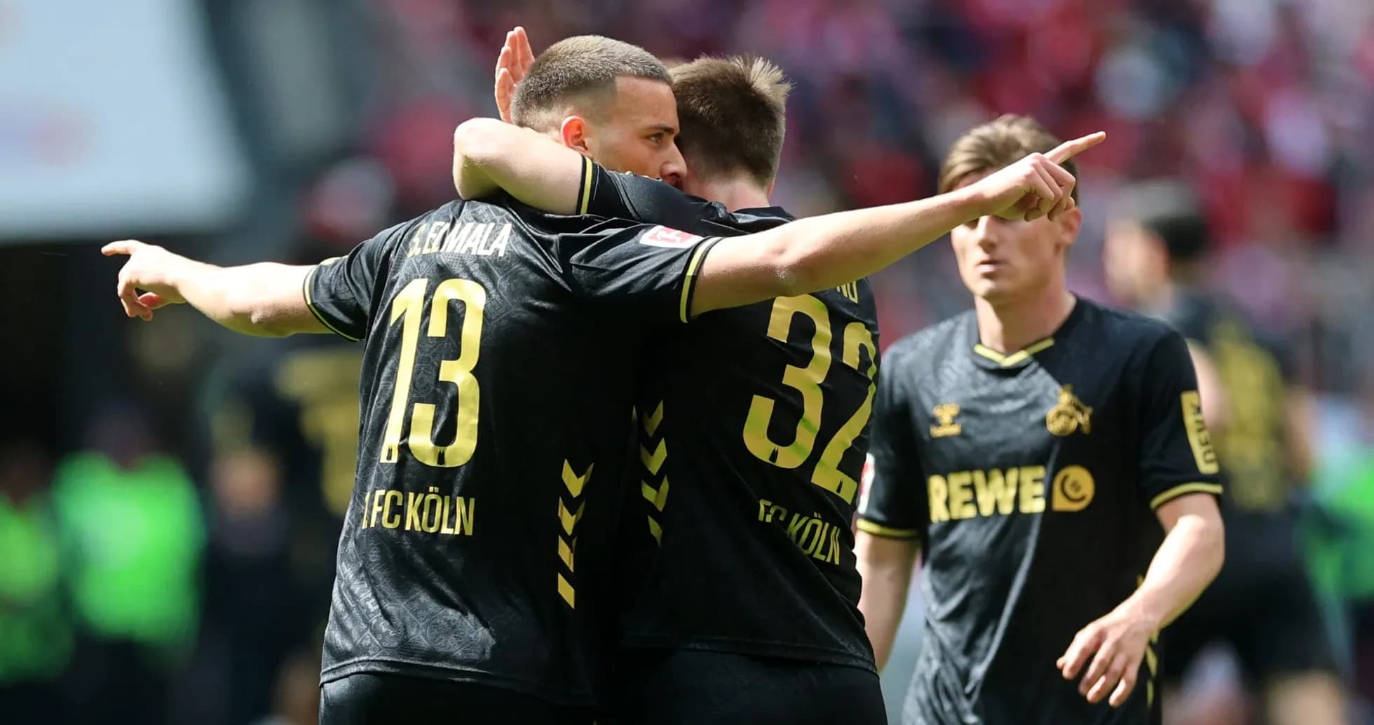 Two FC Köln players celebrating on the pitch