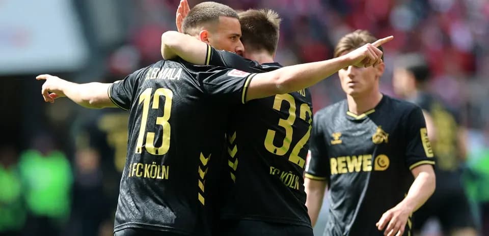 Two FC Köln players celebrating on the pitch