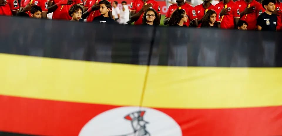 Ugandan team standing during national anthem with flag
