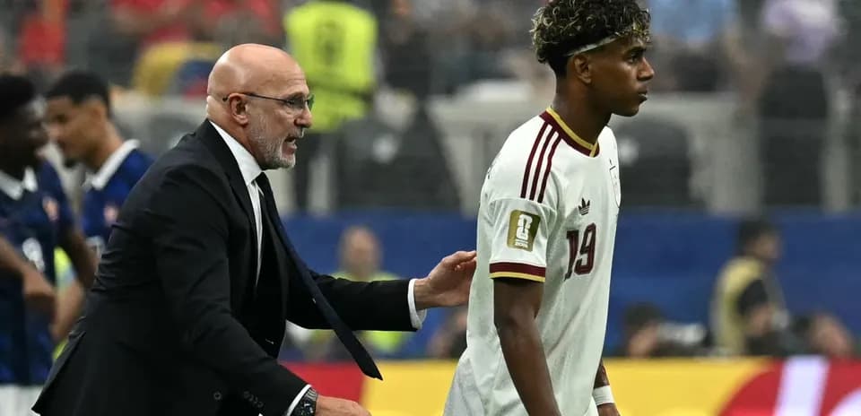 Coach speaking to player on the field after match