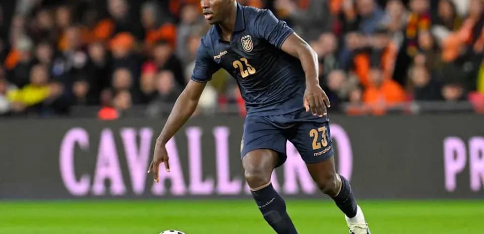 Player in dark jersey dribbling ball on field