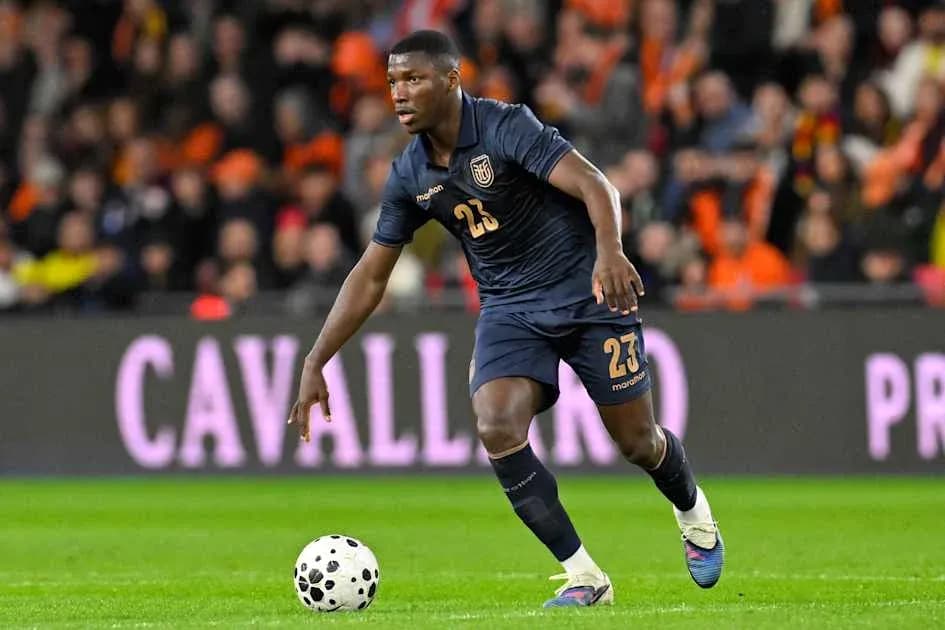 Player in dark jersey dribbling ball on field