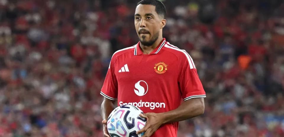 Player in Manchester United kit holding a soccer ball