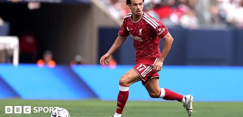 Player in red Liverpool kit dribbling the ball