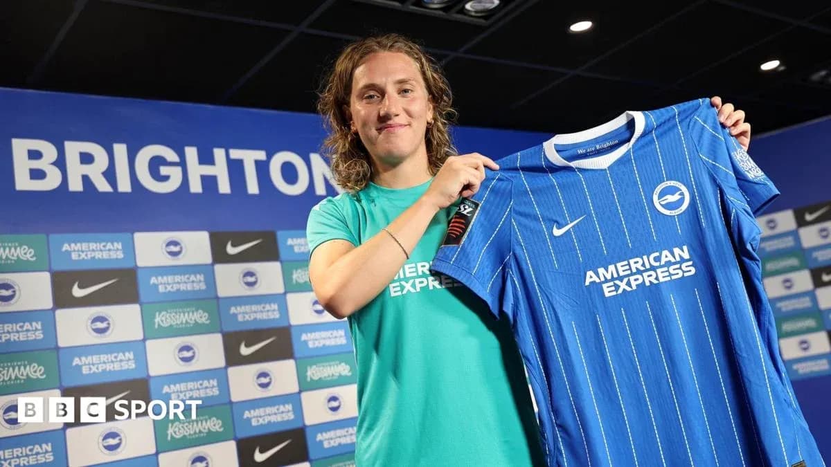 Player holding Brighton jersey at press conference