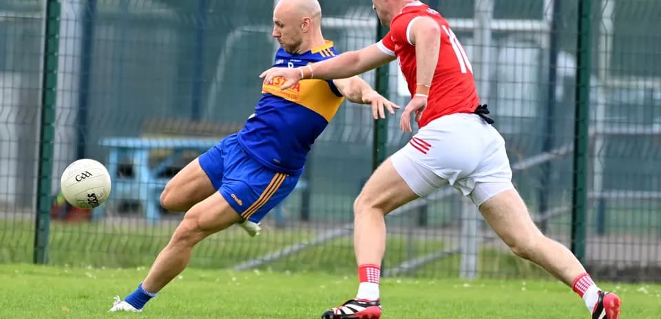 Player in blue attempting to kick ball while tackled